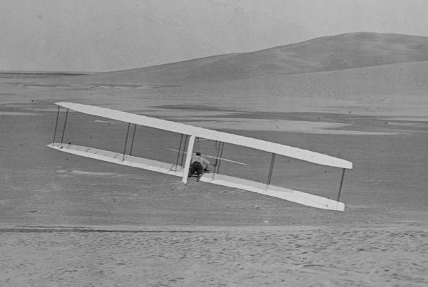 Wilbur Wright, mounted here on a plane, attempts a turn during testing in 1902